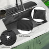 A black silicone kitchen sink drain mat with adjustable caliber and a foldable design is shown on a countertop.