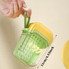 A hand is holding a green plastic leakproof travel container with a yellow lid and a measuring scale.