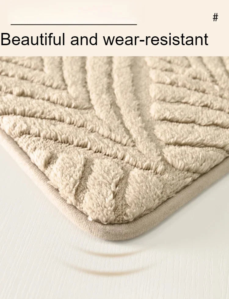Close-up of a beige, textured, wear-resistant bathroom rug with a visible shadow on a white surface.