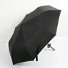 A black folding katana sword umbrella is shown open against a white background.