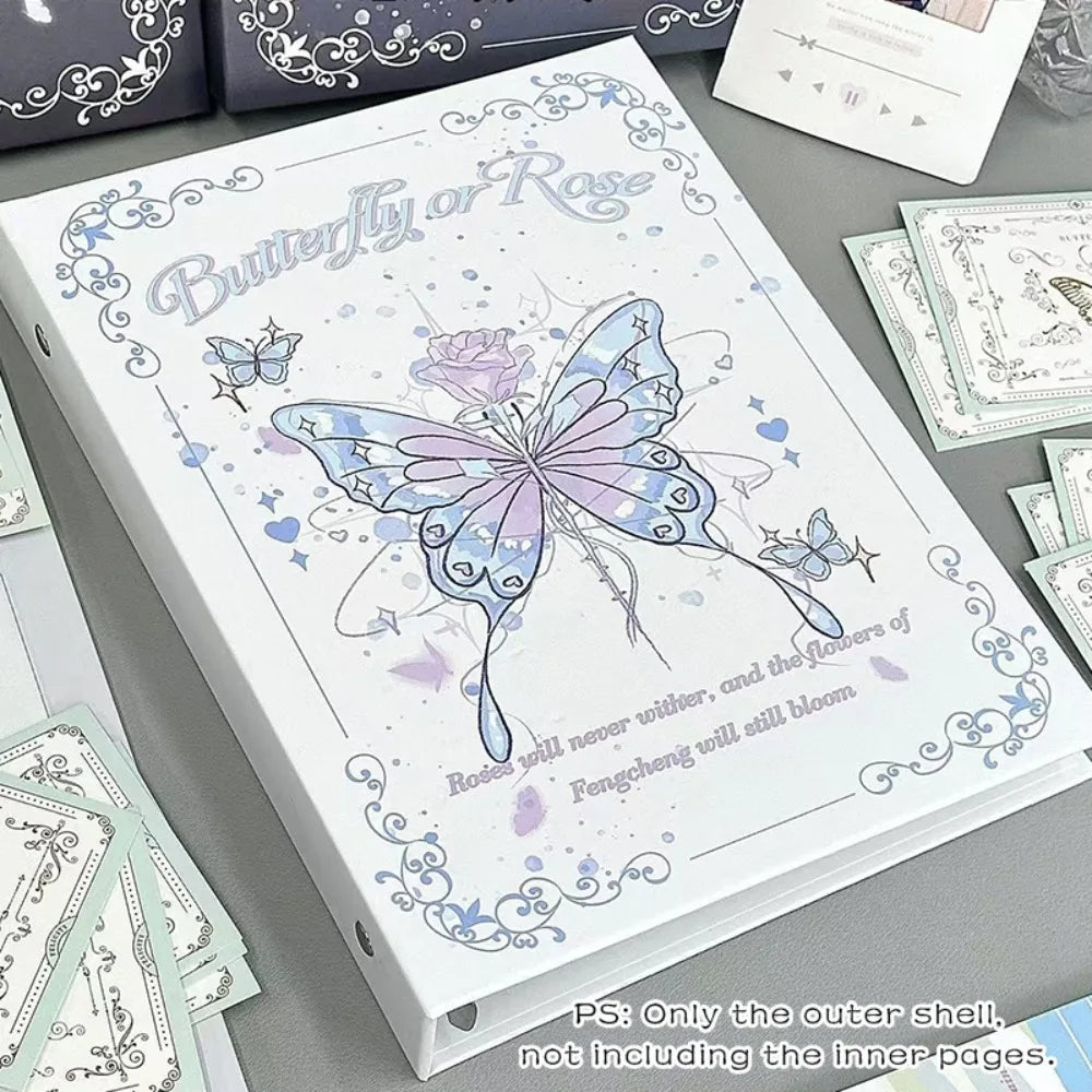 A white photo album featuring a butterfly design and floral elements, with loose leaf pages visible.