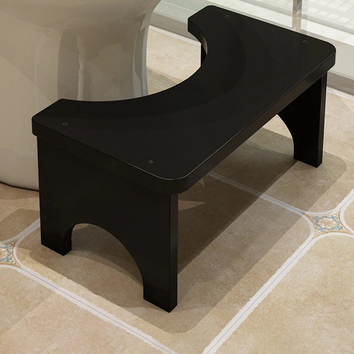 A black portable bamboo toilet squat stool is shown on a light carpet.