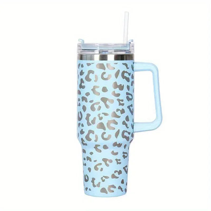 A light blue insulated stainless steel tumbler with a leopard print design and a clear straw.