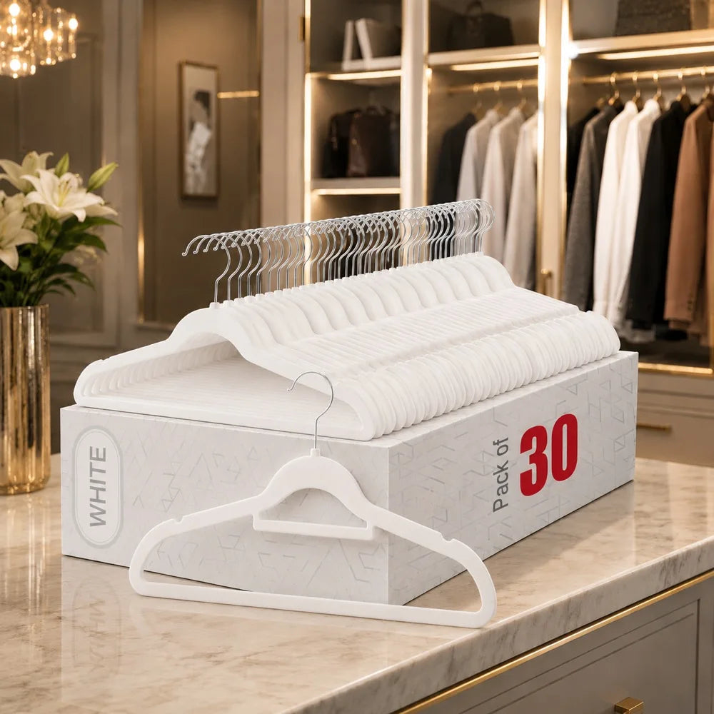 A white box of non-slip velvet hangers with chrome hooks is displayed on a marble countertop.