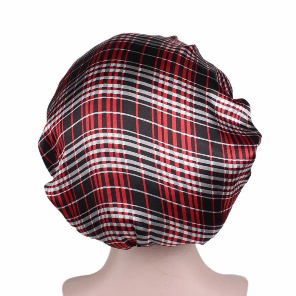 A black and red plaid satin sleep bonnet worn on a mannequin.