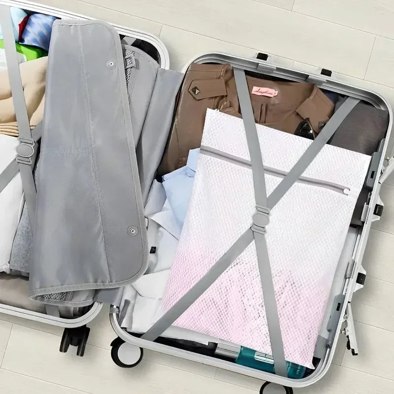 A silver laundry bag with a mesh insert is shown inside a gray rolling suitcase.