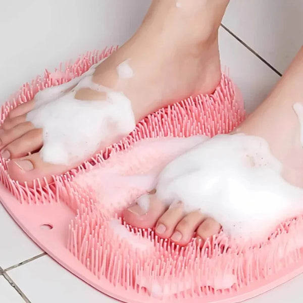 A pink suction cup foot massage mat with white foam is being used for relaxation.