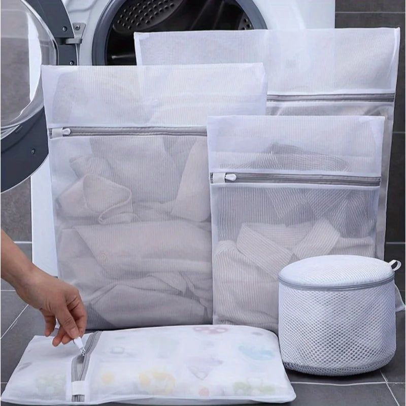 White reusable mesh laundry bags and a white fabric item are shown next to a washing machine interior.