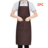 A person is wearing a dark brown chef apron over a light gray shirt, with a 2PC label visible.