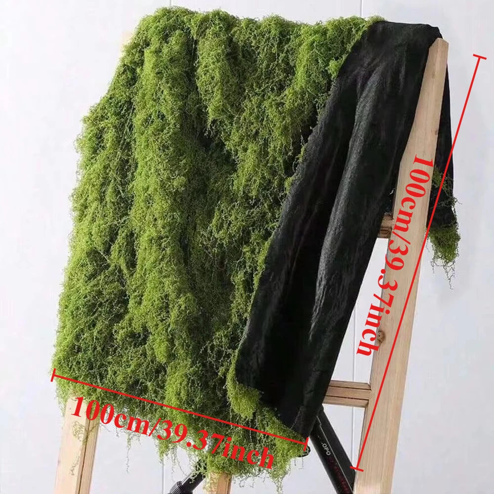 A dark green artificial moss garland draped over a wooden chair, showing its texture and size.