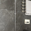 A silver silicone suspension design for a window or surface cleaner hanging on a dark marble wall.