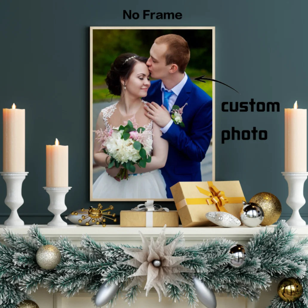 A framed custom photo print of a couple kissing, displayed on a mantel with candles and greenery.