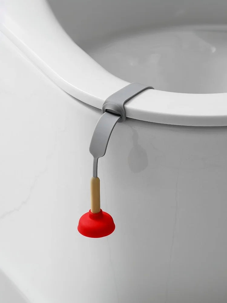 A portable toilet lid lifter with a gray handle and a red rubber plunger is shown against a white ceramic toilet bowl.