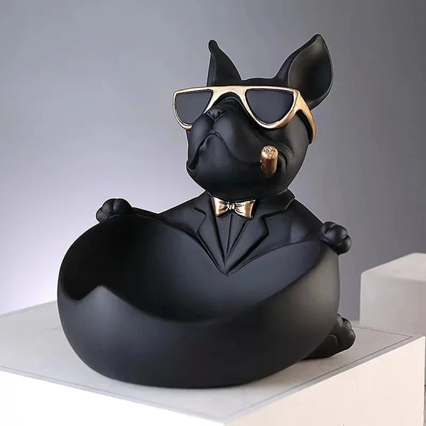 A black French bulldog sculpture wearing sunglasses, holding a coin bank and snack holder.
