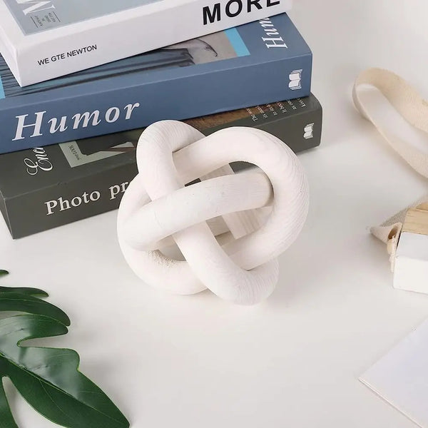 A white rope knot is placed on a surface next to several dark-colored boxes labeled Humor and Photo Print.