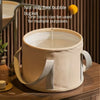 A beige portable folding foot soak tub is shown with a liquid being poured into it.