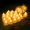 A glass jar filled with glowing LED heart tea lights resting on a wooden surface surrounded by artificial rose petals.