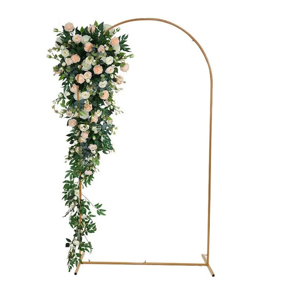 Adjustable gold arch stand decorated with white and pink floral greenery for party backdrop