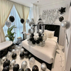 Dormitorio decorado para una fiesta de cumpleaños con globos plateados y negros y un globo de número de papel metálico grande