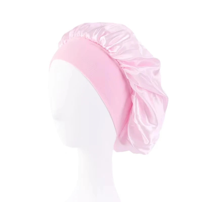 Pink satin wide-brim sleeping bonnet displayed on a white mannequin head.