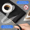Roll of white ironing tape being cut with scissors on a black fabric surface
