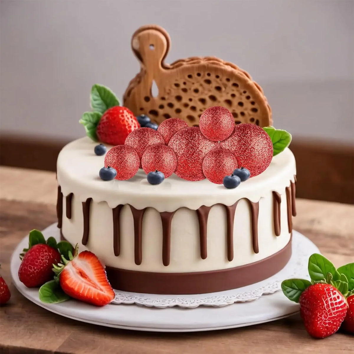 A round cake decorated with strawberries, blueberries, and a wooden animal topper on a white plate.