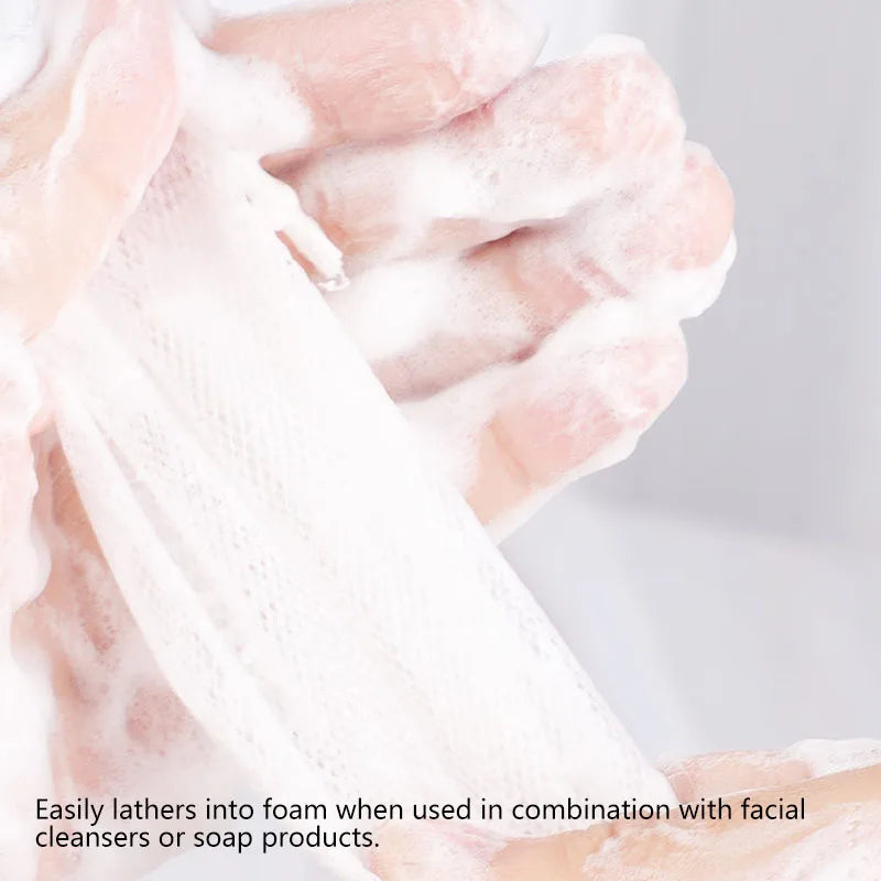 Hands lathering white foam from bulk soap net bags used with facial cleansers or soap products.