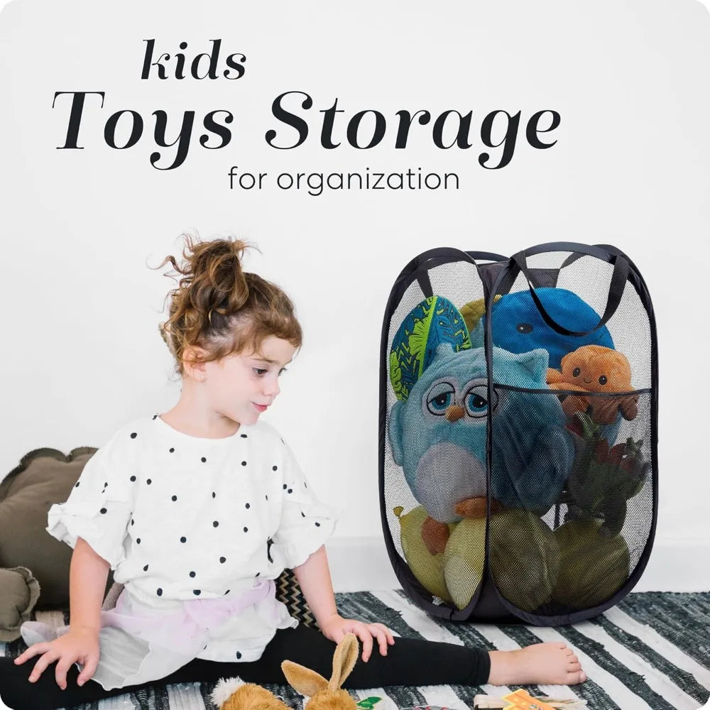 A young girl is sitting on the floor next to a black mesh storage basket filled with various toys for kids organization.