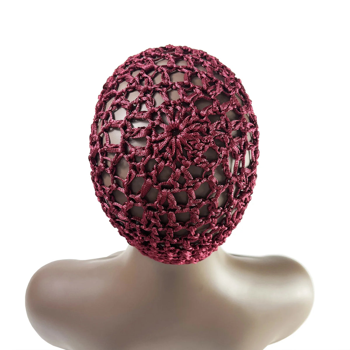 A close-up of a hand-crocheted mesh hair net cap in a deep magenta color displayed on a mannequin head.