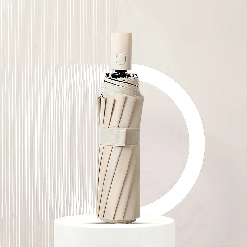 A beige heavy duty automatic windproof umbrella standing upright on a white pedestal.