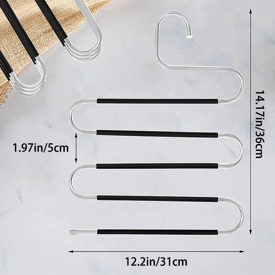 A set of silver S-shaped stainless steel storage racks for hanging pants and towels displayed on a white marble surface.