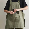 A person wearing a olive green waterproof outdoor work apron over a black shirt.