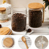 A set of airtight glass spice jars with bamboo lids, filled with dark coffee beans, displayed on a wooden surface.
