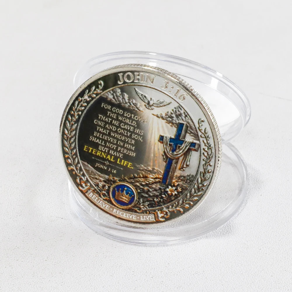A commemorative coin featuring the Bible verse John 3:16 and a cross design.