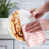 A hand is wiping a round, white cleaning cloth with a pink textured coral fleece cleaning cloth.