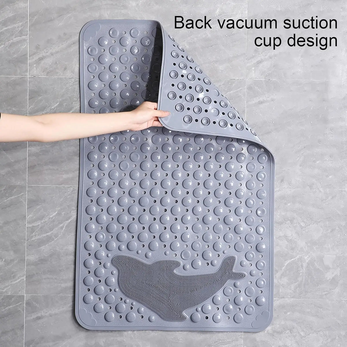 A gray rectangular bath mat with a back vacuum suction cup design is shown being held by a hand.