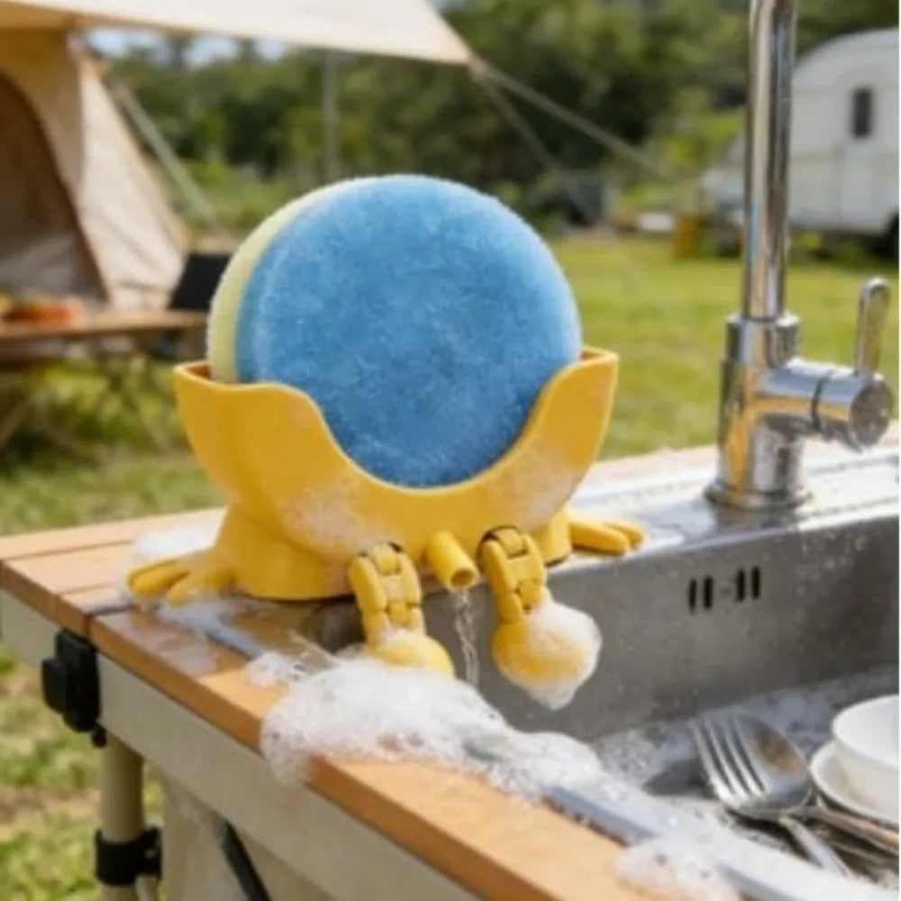 A yellow sponge holder with sponge arms is shown on a wooden surface, used for kitchen drainage.