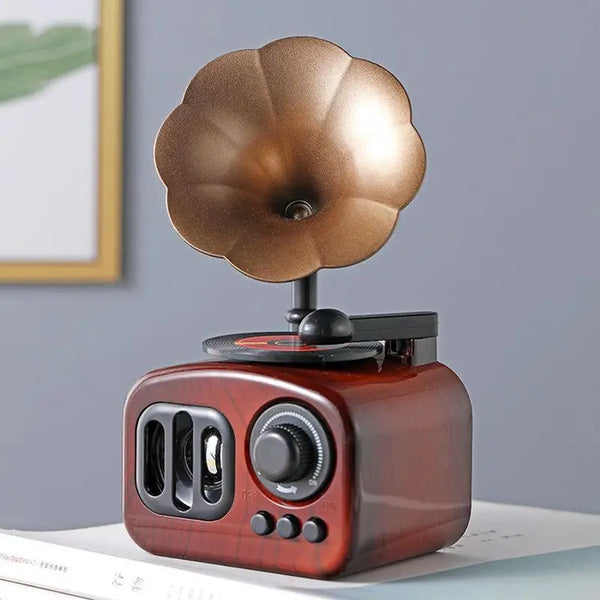 A vintage-style phonograph music box with a copper-colored diaphragm and wooden body sits on a white surface.