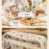 A beige pencil case with transparent pockets and a main compartment, showing various stationery items.