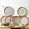 Round rattan serving tray with mother of pearl inlay featuring various decorative patterns.