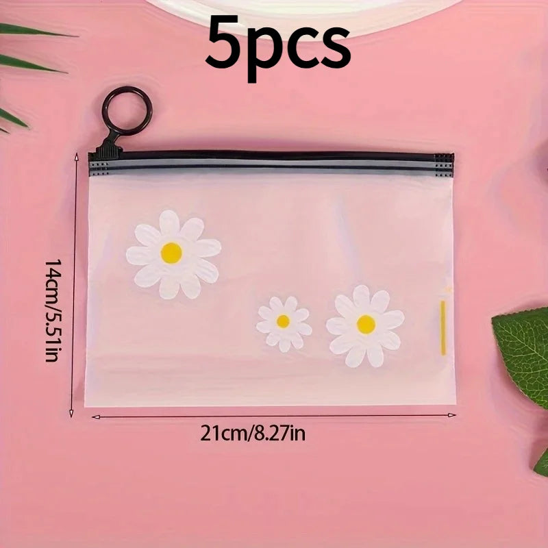 A clear plastic zipper storage bag with a white daisy pattern is shown on a pink background.