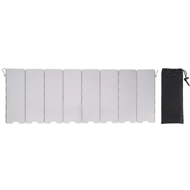 A set of white wind shields for an outdoor gas stove, packaged in a black bag.