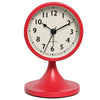 A red round analog alarm clock with a white face and black hands, featuring a metal base.