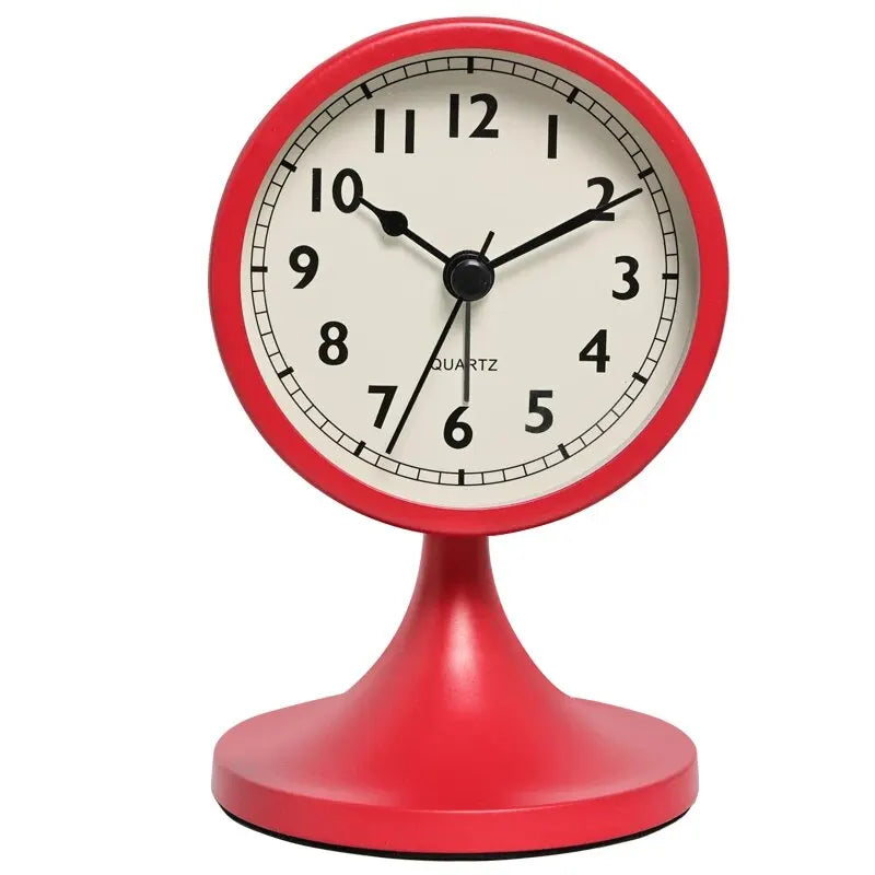 A red round analog alarm clock with a white face and black hands, featuring a metal base.