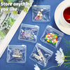 Clear plastic organizer bags containing various small items like jewelry and pills on a blue surface.