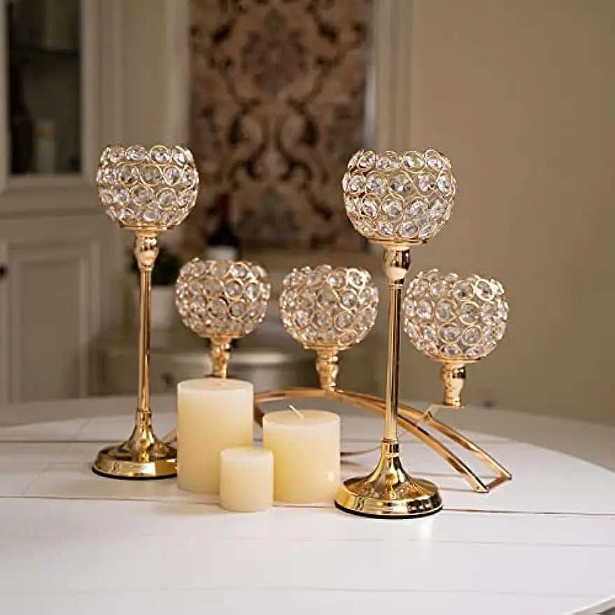 A gold crystal tealight candlestick candelabra set with decorative floral glass holders and white candles.