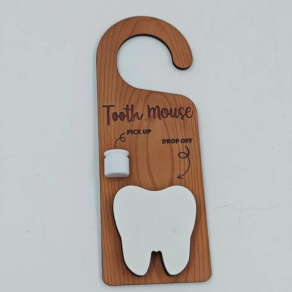 A wooden tooth-shaped door hanger for kids with instructions to pick up and drop off.