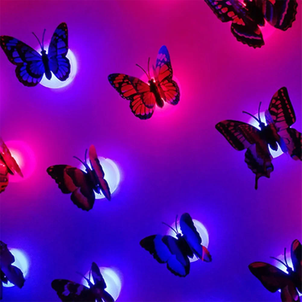 A display of luminous 3D butterfly wall lights in shades of pink, purple, and blue against a dark background.