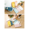 A collection of plastic thickened washboards in various colors including yellow, pink, and blue, shown on a wooden surface.
