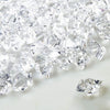 Crushed clear crystal ice stones scattered on a white surface.